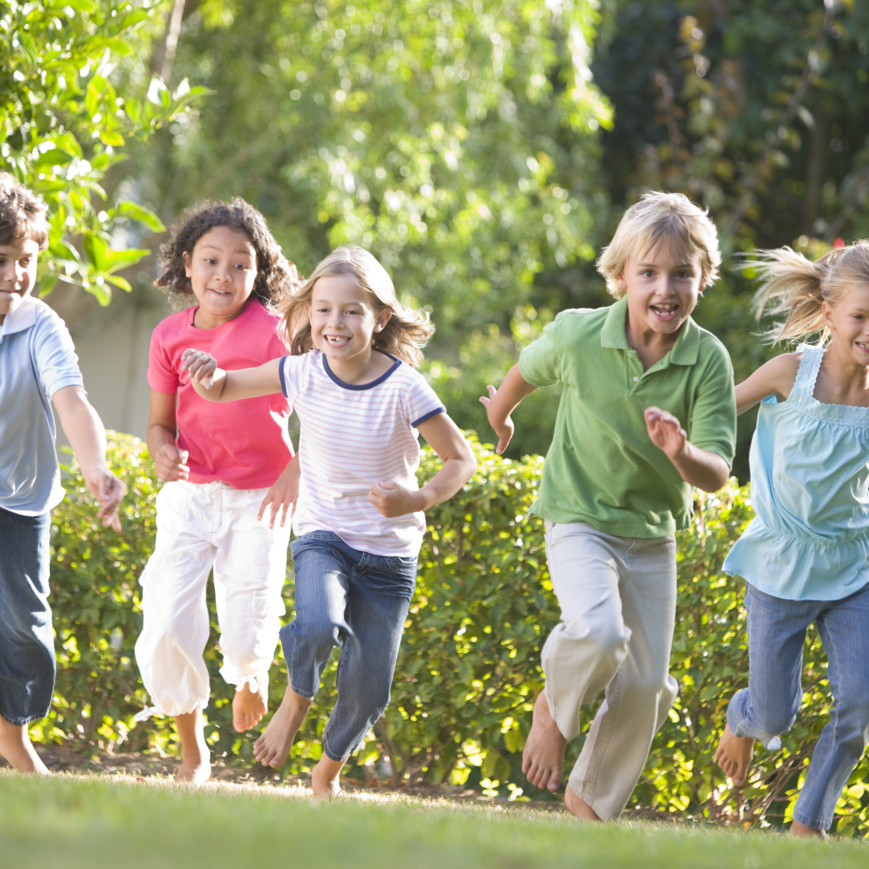 Five young friends running outdoors smiling